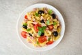 Fusilli pasta salad with tuna, tomatoes, black olives and basil on gray stone background Royalty Free Stock Photo