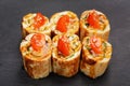 Fusion rolls with omelette and tomatoes on black palte Royalty Free Stock Photo