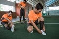 Futsal player straightens his shoelaces while his friend stretches legs