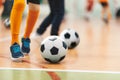 Futsal Soccer Ball on Indoor Training Pitch. Young Players On Sports Practice Running Balls in Blurred Background Royalty Free Stock Photo