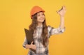 future career. teen girl in helmet making notes. builder kid write in folder. Royalty Free Stock Photo