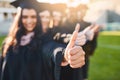 The future depends on what you do today. Closeup shot of two unrecognizable students showing thumbs up on graduation day Royalty Free Stock Photo