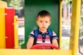 Future driver: toddler boy with serious face playing as truck driver at outdoor playground in park. Child dreams concept Royalty Free Stock Photo