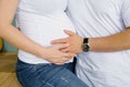 The future father holds his hand on the stomach of the future mother, his pregnant wife. Expectant parents waiting Royalty Free Stock Photo