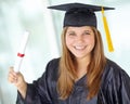 The future is mine. A pretty college student in her graduation gown showing you her degree. Royalty Free Stock Photo