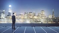 Future vision concept businessman on top of roof and looking on night San Francisco skyline