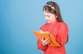 Future writer having literature class. Adorable small child writing literature report. Cute little girl holding book in Royalty Free Stock Photo