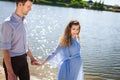 Future mother and father walking near lake Royalty Free Stock Photo