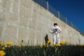 Futuristic astronaut in a helmet against gray walls. Fantastic Cosmic Costume.