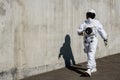 Futuristic astronaut in a helmet against gray walls. Fantastic Cosmic Costume.