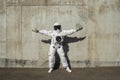 Futuristic astronaut in a helmet against gray walls. Fantastic Cosmic Costume.