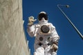 Futuristic astronaut in a helmet against gray walls. Fantastic Cosmic Costume