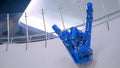 Futuristic big blue mechanical robotic hand showing devil horn gesture