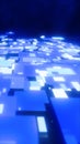 Futuristic blue digital grid surface with glowing geometric tiles, representing data flow, technology networks, and Royalty Free Stock Photo