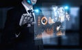 Futuristic Businessman with Robotic Arm Displaying Digital Analytics and Data Visualizations in a Dark Office Royalty Free Stock Photo