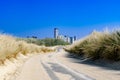 Futuristic city looming at the and of an empty road, which runs through dunes. Summer. Vacation. Path to unknown.Path to success.