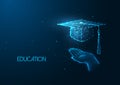Futuristic education concept with glowing low polygonal human hand holding graduation cap