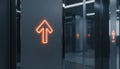 A futuristic elevator control panel with glowing orange up arrows in a sleek metallic hallway, representing innovation, movement Royalty Free Stock Photo