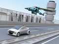 Futuristic flying car flying over a silver sedan driving on highway