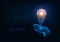 Futuristic idea, creativity concept with glowing low polygonal light bulb and human hand. Royalty Free Stock Photo