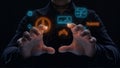 Futuristic interface interaction: hands gesturing holographic icons and digital elements in dark setting