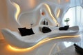 Futuristic living room featuring a stylish curved white couch as its focal point