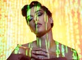 Futuristic, neon and projection on cyberpunk woman thinking with edgy makeup and hair style in studio. Dystopian