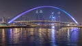 Futuristic Pedestrian Bridge over the Dubai Water Canal Illuminated at Night timelapse, UAE. Royalty Free Stock Photo