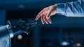 Futuristic Robot Arm Touches Human Hand in Humanity and Artificial Intelligence Unifying Gesture