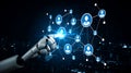 Futuristic robot hand interacting with digital network of interconnected nodes representing human figures in a high-tech Royalty Free Stock Photo