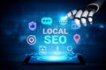 Futuristic Robot Hand Interacting with Digital Local SEO Icons on Tablet Screen in a Blue Tech Environment for Marketing Royalty Free Stock Photo