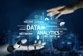Futuristic robot hand reaching out to human hand with digital data analytics visualizations in a technological landscape Royalty Free Stock Photo