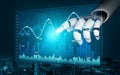 Futuristic robotic hand interacting with digital data visualization and financial graphs in a high-tech abstract Royalty Free Stock Photo