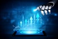 Futuristic robotic hand interacting with digital tablet displaying financial growth graphs and arrows symbolizing Royalty Free Stock Photo
