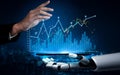 Futuristic robotic hand interacting with smartphone displaying stock market analytics and financial data with glowing Royalty Free Stock Photo