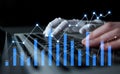 Futuristic robotic hand typing on keyboard with digital stock market graphs illustrating data analysis and artificial Royalty Free Stock Photo