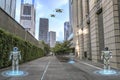 Futuristic robots patrol urban walkway with drones overhead Royalty Free Stock Photo