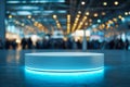 Futuristic round display platform lit with blue neon light on floor in spacious modern venue with blurred crowd and warm ceiling Royalty Free Stock Photo