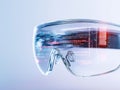 Futuristic smart glasses display data on lenses. Transparent eyewear shows lines of code, technical information. Modern tech