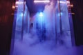 A futuristic steam-filled pod with blue lighting at a wellness center, providing a unique relaxation experience for