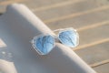 Futuristic sunglasses model having a special design with big silver lenses closeup shoot outside in a summer day