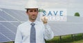 A futuristic technical expert in solar photovoltaic panels, selects the `Save energy` function using pure renewable energy. The co Royalty Free Stock Photo