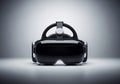 A futuristic virtual reality headset on a smooth surface, set against a neutral gradient background. Royalty Free Stock Photo