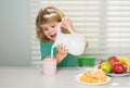 Fuuny little boy pouring whole cows milk for breakfast. Child boy eating organic healthy food. Healthy vegetables with