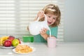 Fuuny little boy pouring whole cows milk for breakfast. Child boy eating organic healthy food. Healthy vegetables with