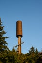 5G cellular antenna covered by a brown visual shield, installed on a wood power line monopole, sunny fall day