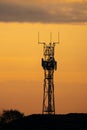 5G controversial radio mobile telephone broadcast transmitter mast silhouette at golden hour sunset. Summer sky with clouds