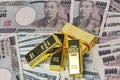 5 of  999.9 % of 1000 g Gold bars  placed on dallar banknotes  and Yen bank notes Royalty Free Stock Photo