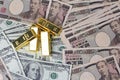 5 of  999.9 % of 1000 g Gold bars  placed on dallar banknotes  and Yen bank notes Royalty Free Stock Photo