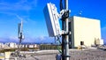 5G mobile telecommunication smart cellular radio network antennas on a mast on the roof broadcasting signal waves Royalty Free Stock Photo